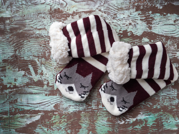 带毛和条纹的温暖袜子，带有猫脸的脚趾，俯视图图片下载