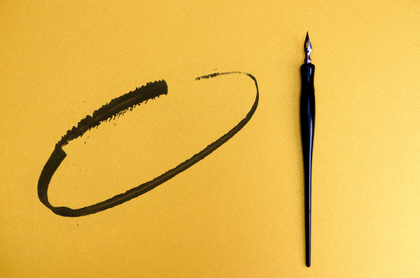 在空白的彩色纸上有墨点和线条的书法笔。文本。前视图。图片下载