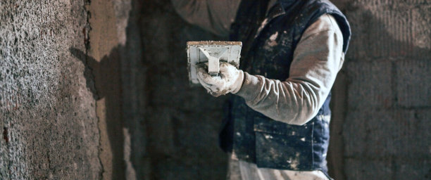 真正的建筑工人在新房子的墙壁上工作。图片下载