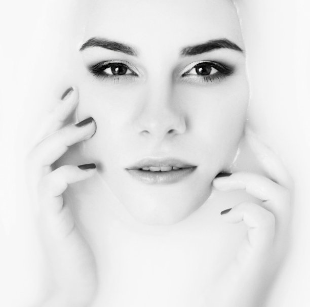 在牛奶浴中的美女模特。年轻化护肤理念。一位皮肤柔软的美丽年轻女子正在牛奶浴中放松。图片下载