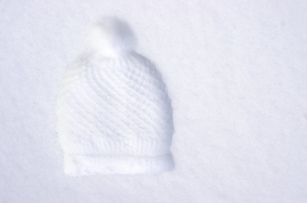 冬季帽子与绒球印在白色的雪图片下载