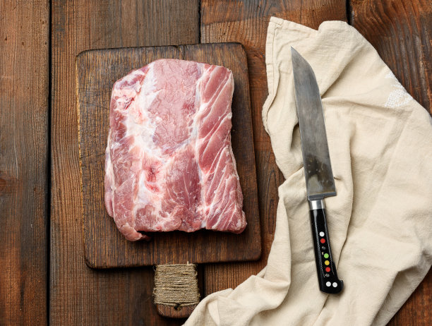 生猪里脊放在木砧板上，俯视图图片下载