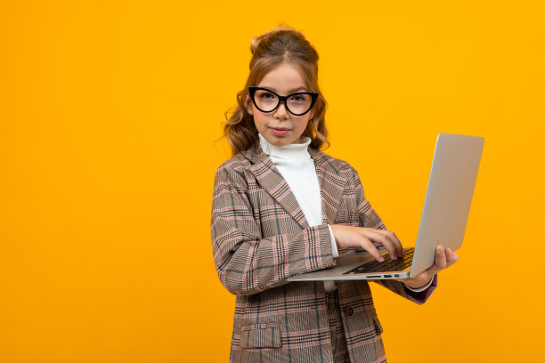 严肃聪明的白人女学生戴着眼镜，穿着西装和夹克，手里拿着笔记本电脑，橙色的背景上有拷贝空间图片下载