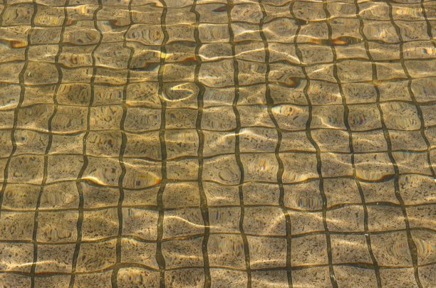 以老水池中的太阳眩光为背景的抽象波浪图片下载