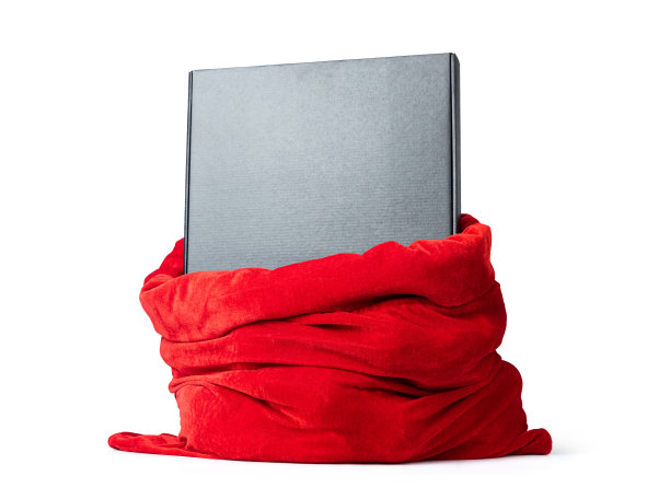 红色的圣诞老人袋子里装着礼物的黑色纸箱，孤立在白色的背景上。文件包含到隔离的路径。图片下载