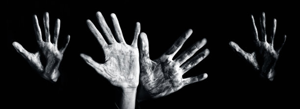 近距离拍摄的手与一些油漆在它孤立的黑色背景，水平拍摄。图片下载