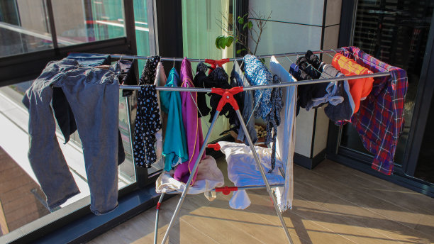 多色衣物在室内衣架上晾干图片下载