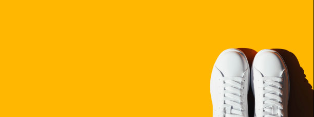 橙色背景上白色运动鞋的横幅。图片下载