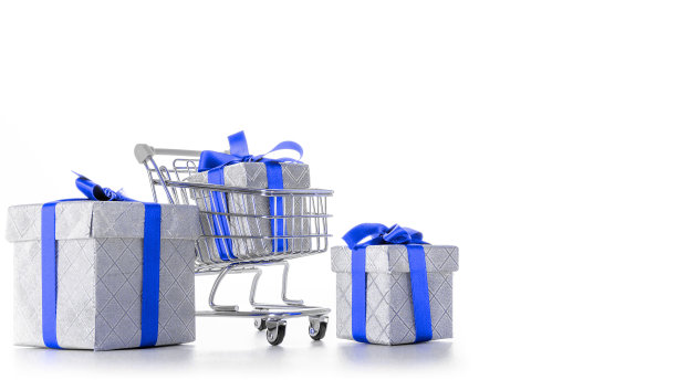 礼物盒孤立。手推车超市与圣诞或生日礼盒隔离在白色背景。销售、折扣、购物狂的概念。消费社会的趋势。图片下载
