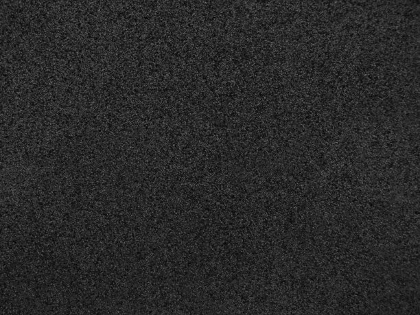 黑石的背景。这所房子的墙壁表面有大理石碎片的纹理。黑色抽象粗糙的背景。素材图片