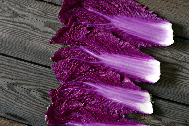 木质背景上的新鲜紫白菜叶子。平的。紫白菜叶，生菜叶。时令蔬菜，俯视图。图片下载