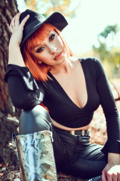 穿着皮衣的女牛仔在树下放松图片下载