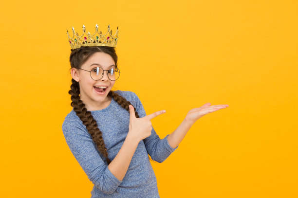 开始为初中舞会做准备吧。快乐的孩子指着摊开的手。小公主赠品。产品推广。市场营销和销售。产品广告。你需要这个产品，复制空间图片下载