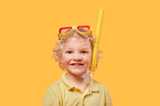 一个戴着面罩和通气管的孩子在夏天微笑着看着镜头。图片下载