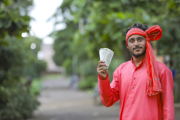 年轻的印度农民拿着钱摆姿势图片下载
