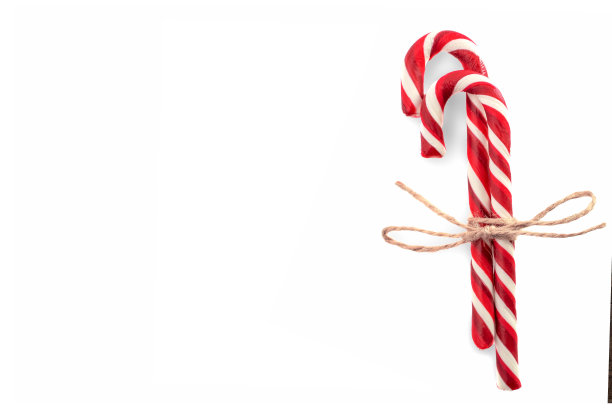两个糖果手杖的特写与绳弓孤立的白色。copyspace。与薄荷糖的最小组成。俯视图图片下载