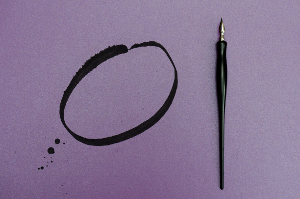 在空白的彩色纸上有墨点和线条的书法笔。文本。前视图。图片下载