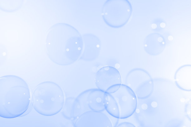 透明透明的肥皂泡漂浮在蓝色背景上。摘要，自然清新的夏天有蓝色的质感。图片下载