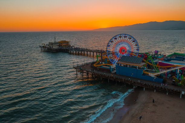 日落时分的圣塔莫尼卡码头，灯光倒映在太平洋上图片下载