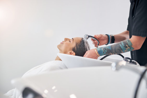 不知名的造型师和一个穿着睡袍闭着眼睛的模特图片下载