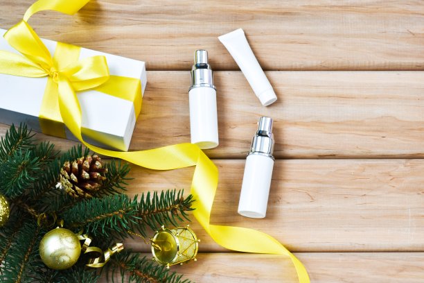 护肤彩妆瓶上以杉木树枝为背景。木制背景上的空白容器。给女人的圣诞礼物。冬季化妆品。副本的空间。广告卡。图片下载