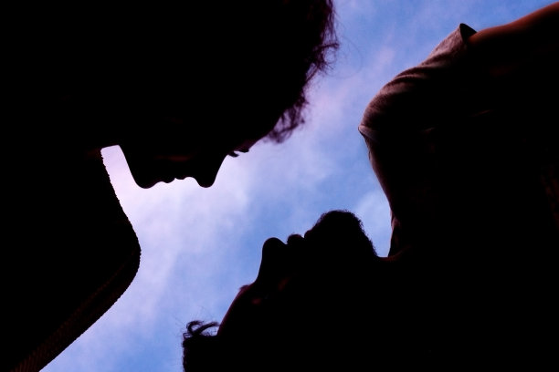 天空背景上男人和女人的剪影。图片下载