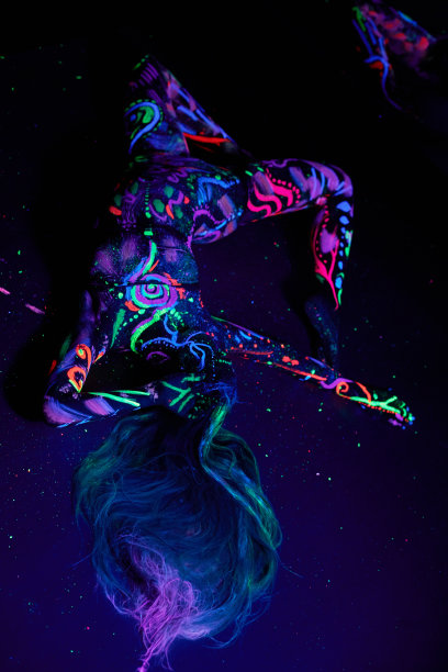 艺术女人的身体艺术在紫外线下跳舞的身体。鲜艳的抽象画上霓虹色的女子身体。彩色的头发和脸。噪音，焦点模糊图片下载