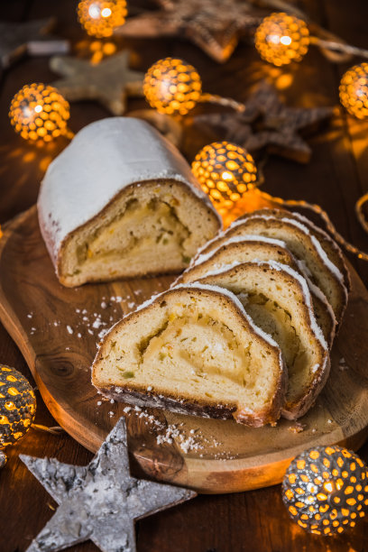 圣诞偷在木板上，灯和圣诞装饰在木制的背景，传统的德国圣诞蛋糕，垂直股票照片图片下载