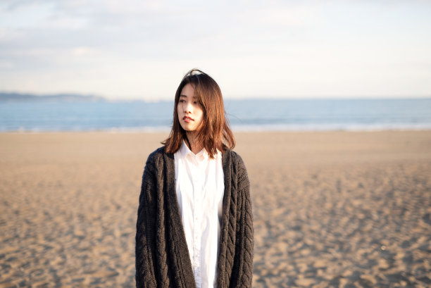 黄昏时分沙滩上年轻女子的肖像图片下载