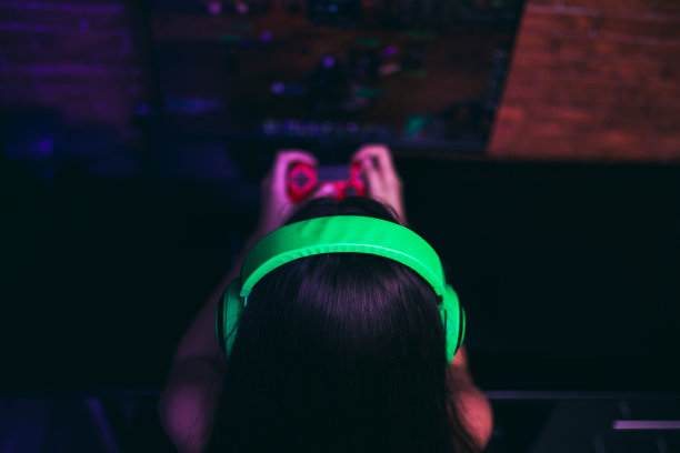电脑游戏，玩的地方，年轻的玩家戴着耳机玩电子游戏图片下载