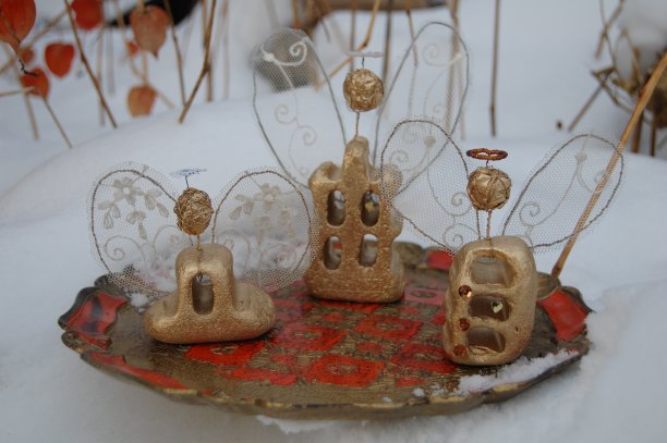 三个自制的天使站在雪地里的托盘上。图片下载