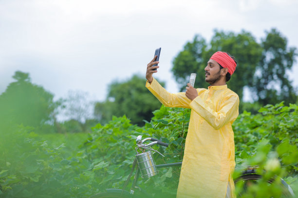 印度农民在棉花地里与钱自拍，表现出快乐的表情图片下载