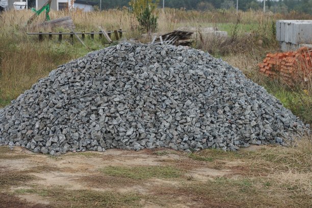 一大堆灰色的碎石堆在绿色的草地上图片下载