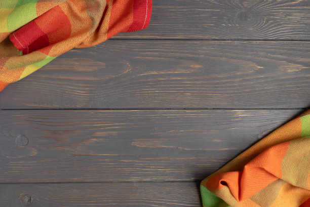 彩色亚麻毛巾在灰色木质背景与文字空间。布局模板。图片下载