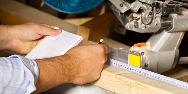 木匠用圆锯切割木条，他锯木条，建筑和家庭装修。木匠的工作概念图片下载