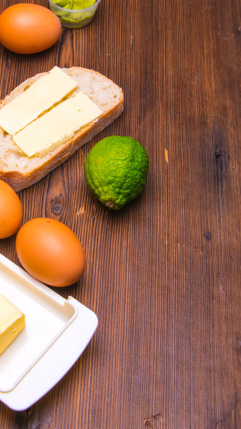 三明治，面包和黄油，鸡蛋，酸橙，黄油煎饼放在一张木桌上，有空间写文章，特写，图片下载