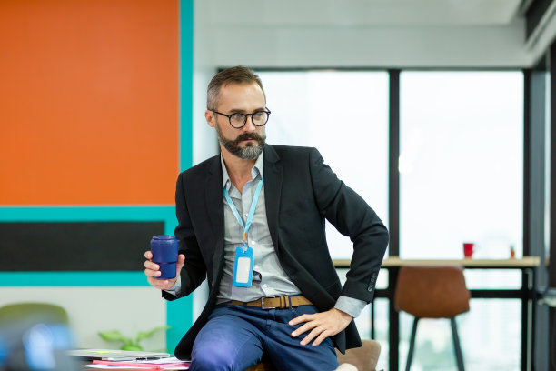 自信的商人穿着西装戴着眼镜在现代办公室工作的肖像。业务及办公理念图片下载