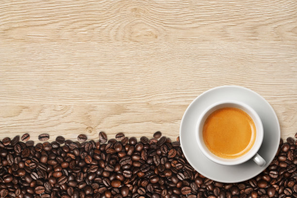 淡木桌上放着一杯浓咖啡和咖啡豆图片下载