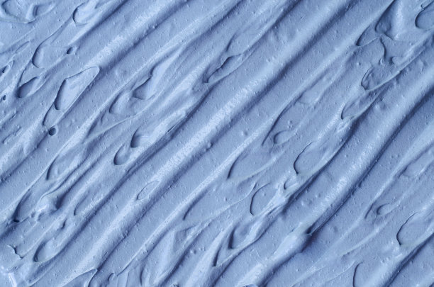 淡蓝色面膜(面膜、面霜、裹体)质地近距离，选择性聚焦。抽象的背景与画笔笔触。图片下载