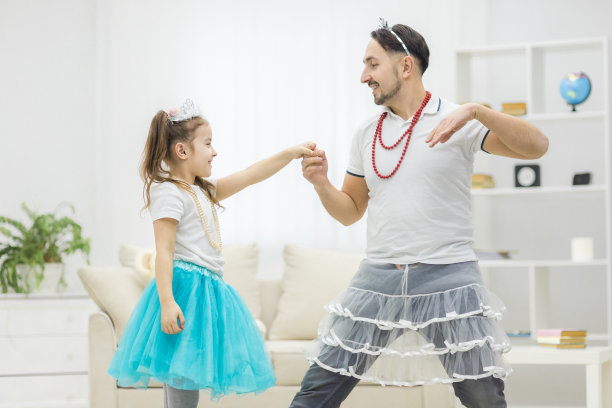 英俊的年轻人和他可爱的小女孩在家里跳舞的照片。图片下载