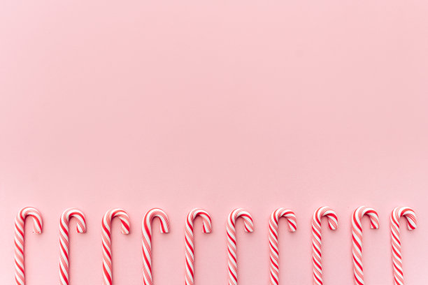 在粉红色背景上的圣诞糖果手杖俯视图。图片下载