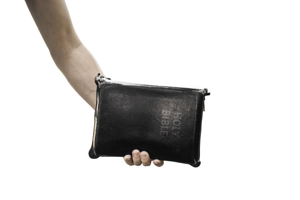 手握旧圣经孤立在白色背景上。剪切路径。图片下载