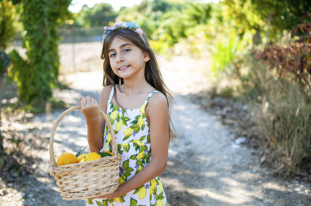 漂亮女孩对着有机橙树摆姿势图片下载