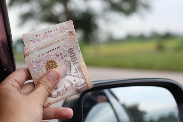 一个人坐在车里拿着钱理财的概念图片下载