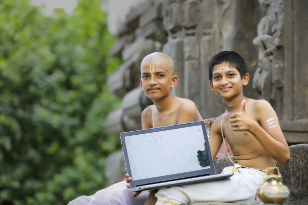 亚洲/印度男孩展示笔记本电脑屏幕图片下载
