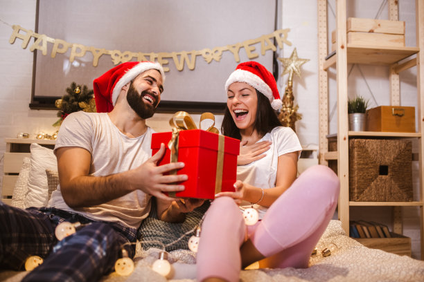一对迷人的年轻夫妇正在家里一起庆祝节日。图片下载