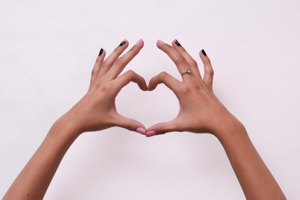 白人女孩的手在白色背景上显示心脏图片下载