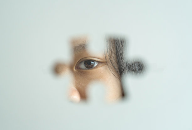 自闭症和自闭症儿童的眼睛背景与拼图作为象征前景。图片下载