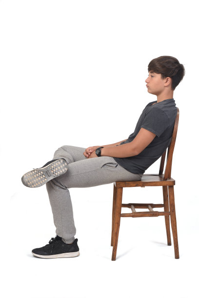 一个十几岁的男孩坐在一张白色背景的椅子上，图片下载