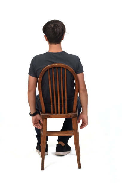 一个十几岁的男孩坐在一张白色背景的椅子上图片下载